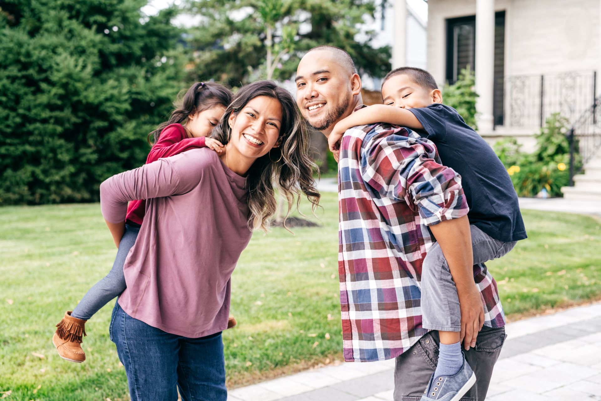 a family playing in front of their house